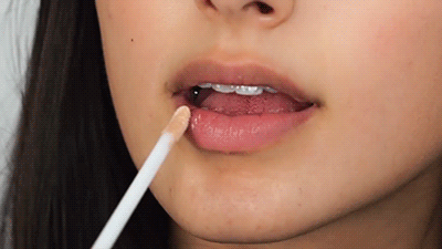 Woman applying Perfect Skin Conditioning Lip Gloss to lips
