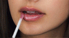 Woman applying rock star Perfect Skin Conditioning Lip Gloss on lips