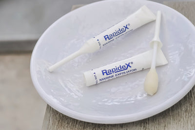 Two Rapidex Exfoliator tubes on a white plate. One tube is opened.