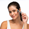 Female model holding Repechage® Silver Ball Massager up to cheek